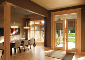 Energy efficient Pella Designer Series wood patio doors connecting dining room to outdoor space, highlighting classic wood design and bright interiors